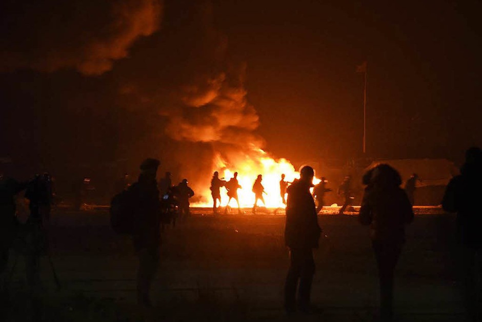 In der Nacht brannten Mülleimer und Teile des Lagers. Morgens reihten sich Hunderte Flüchtlinge auf, um registriert zu werden. Andere versuchen auf eigene Faust, das Lager zu verlassen. (Foto: AFP) In der Nacht brannten Mülleimer und Teile des Lagers. Morgens reihten sich Hunderte Flüchtlinge auf, um registriert zu werden. Andere versuchen auf eigene Faust, das Lager zu verlassen. (Foto: AFP)
