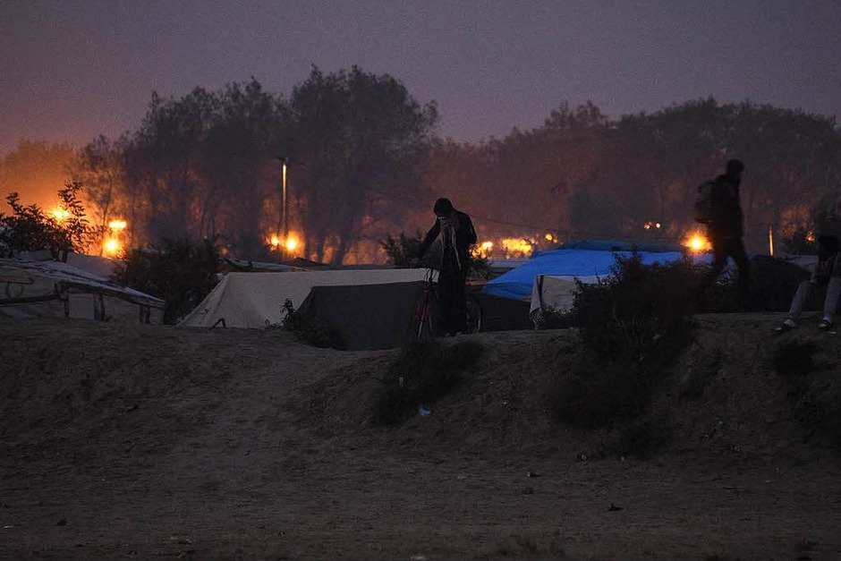 In der Nacht brannten Mülleimer und Teile des Lagers. Morgens reihten sich Hunderte Flüchtlinge auf, um registriert zu werden. Andere versuchen auf eigene Faust, das Lager zu verlassen. (Foto: AFP) In der Nacht brannten Mülleimer und Teile des Lagers. Morgens reihten sich Hunderte Flüchtlinge auf, um registriert zu werden. Andere versuchen auf eigene Faust, das Lager zu verlassen. (Foto: AFP)