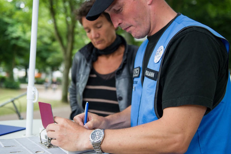 Ein Polizist nimmt am 10.07.2017 in Hamburg bei einem Infomobil der Polizei die Daten einer Frau auf, die während der Krawalle in Hamburg Sachschaden erlitten hat. Bei dem Infomobil können Betroffene Sachschaden melden, der während des G20-Gipfels entstanden ist. (Foto: dpa) Ein Polizist nimmt am 10.07.2017 in Hamburg bei einem Infomobil der Polizei die Daten einer Frau auf, die während der Krawalle in Hamburg Sachschaden erlitten hat. Bei dem Infomobil können Betroffene Sachschaden melden, der während des G20-Gipfels entstanden ist. (Foto: dpa)