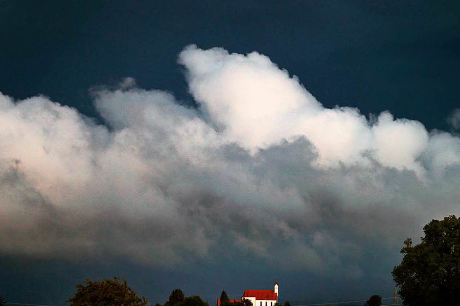 Wolken türmen sich über der Wallfahrtskirche Sankt Alban bei Aitrang in Bayern. (Foto: dpa) Wolken türmen sich über der Wallfahrtskirche Sankt Alban bei Aitrang in Bayern. (Foto: dpa)