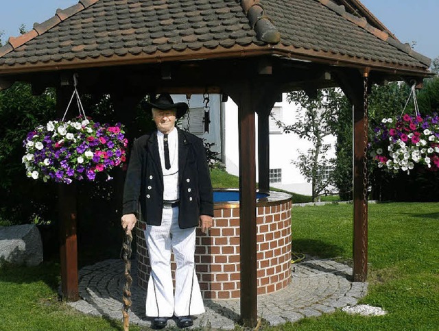 Maurermeister Eduard Wieck mit seinem ...elbst gemauerter Regenauffangbrunnen.   | Foto: Sylvia Bleckmann