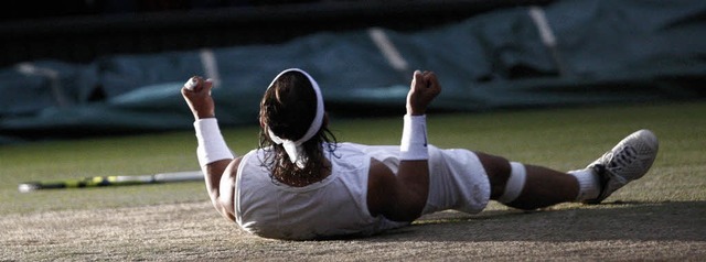 Endlich geschafft: Rafael Nadal suhlt ...auf dem heiligen Rasen von Wimbledon.   | Foto: afp