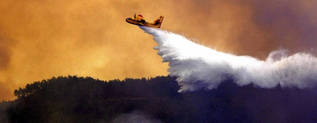 Ein Lschflugzeug ldt seine Wasserladung ber  den Wldern von Rhodos ab.   | Foto: dpa