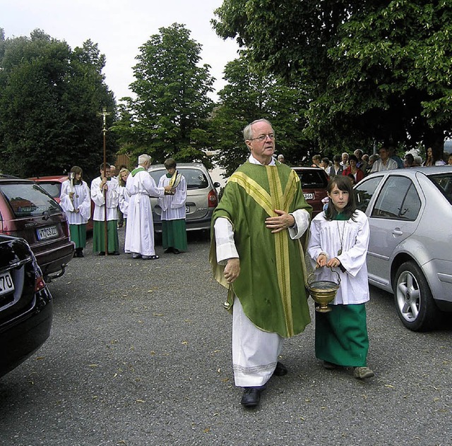 Pfarrer Wolfgang Auer mit Ministranten...hinten)  whrend der Fahrzeugsegnung.   | Foto: Michael Rber