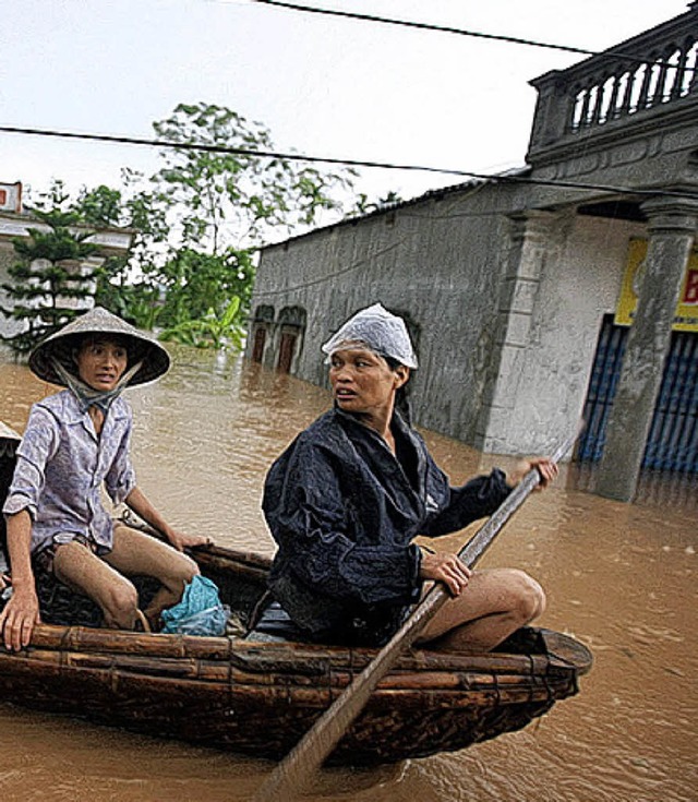 In einem Boot flchten Vietnamesen aus ihren Husern.   | Foto: AFP