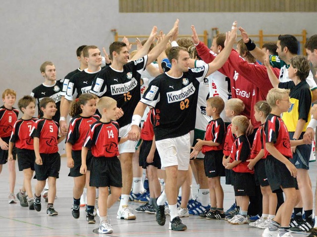 Die Minis der Handballgemeinschaft Ml...en  die Handballprofis aufs Spielfeld.  | Foto: Volker Mnch