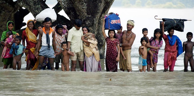 Mit Hab und Gut auf Rcken und Kpfen:...der fliehen vor den berschwemmungen.   | Foto: AFP