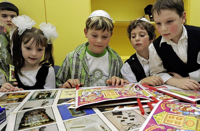 Schler der neuen  jdischen Grundschule in Stuttgart betrachten Papierbgen.  | Foto: dpa