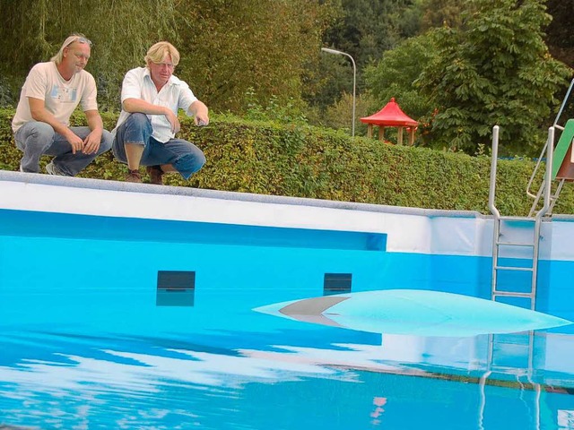 Schwimmmeister Dieter Bless und Thomas...r Folie, die immer noch oben schwimmt.  | Foto: Michael Krug