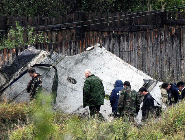 Rettungskrfte vor Trmmern der Maschine  | Foto: afp