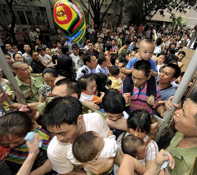 Chinesische Eltern warten vor einem Kr...b auch ihre Kinder vergiftet wurden.    | Foto: AFP
