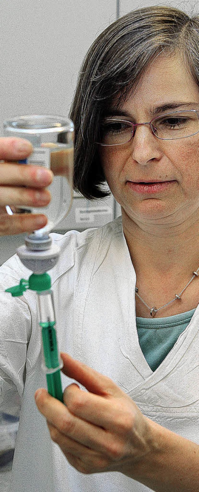 Eine Krankenschwester zieht eine Spritze auf.   | Foto: DPA