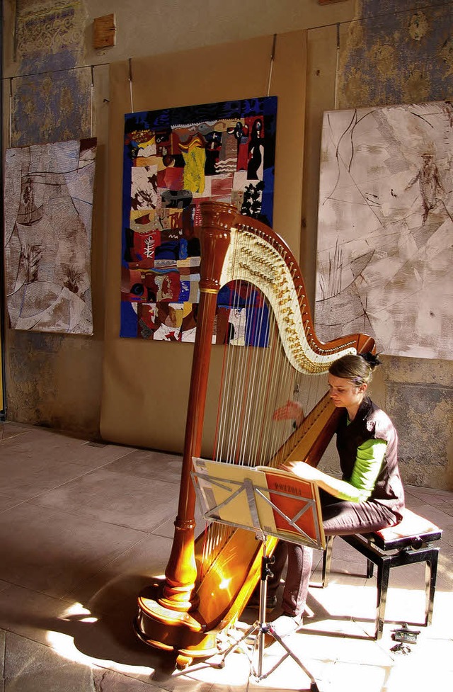Mirjam Weschle mit Harfe vor den Bildern von Alfons Wei.   | Foto: Dinger