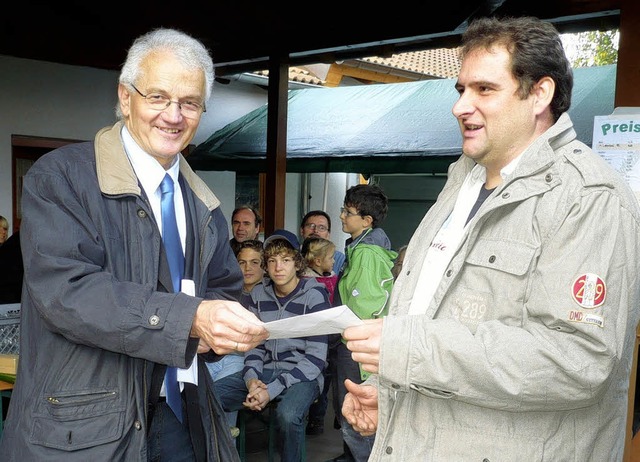 Ortsvorsteher Lothar Giler (links) b...g des Vereins ein  Jubilumsgeschenk.   | Foto: Dieter Fink