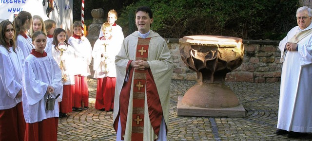 Pfarrer Gianluca Carlin Heimbach dankt...it dem ber 200 Jahre alten Taufstein.  | Foto: Karlernst Lauffer