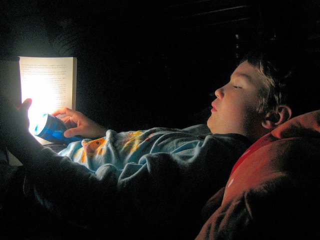 Endlich kann das Lesen beginnen: Sebastian hat seine Taschenlampe angeknipst.  | Foto: Privat