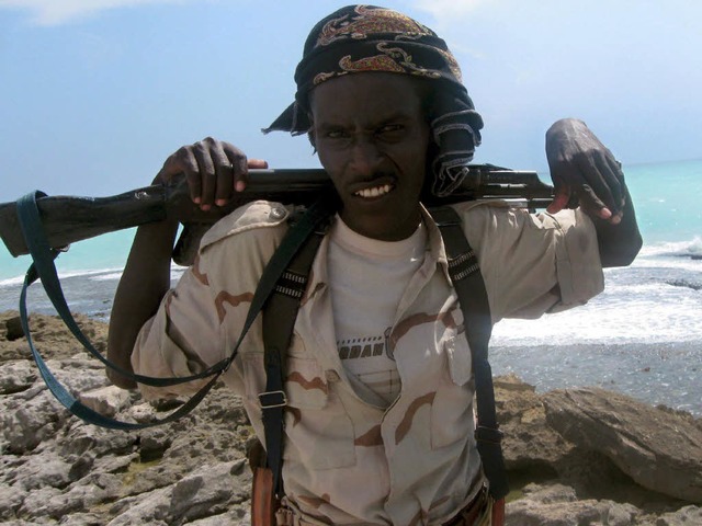 Ein somalischer Pirat steht an der Kste von Hobyo Wache.  | Foto: dpa
