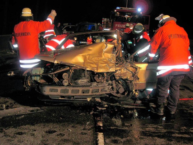 Feuerwehrleute am total zerstrten Mercedes des Fahranfngers.  | Foto: Polizei