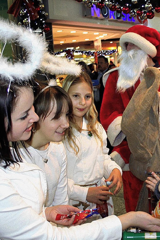 Der Nikolaus und seine Begleiterinnen ... Rheincenter Prsente an die Kinder.    | Foto: Privat