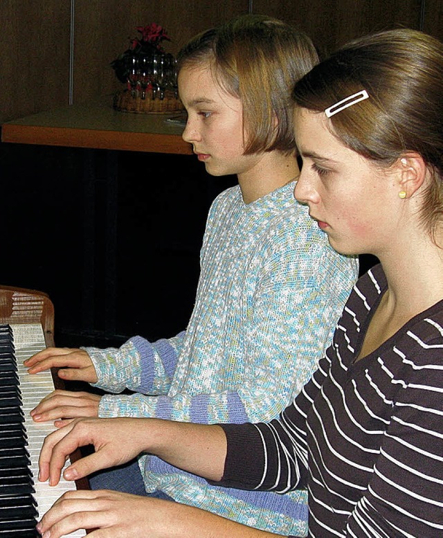 Annika (vorne) und Alisa begleiteten d...enen Weihnachtslieder auf dem Klavier.  | Foto: Alfons Ebner