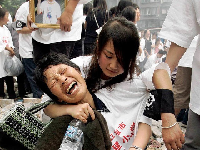 Eltern trauern vor den Trmmern einer ...m Erdbeben am 12. Mai zerstrt wurde.   | Foto: AFP