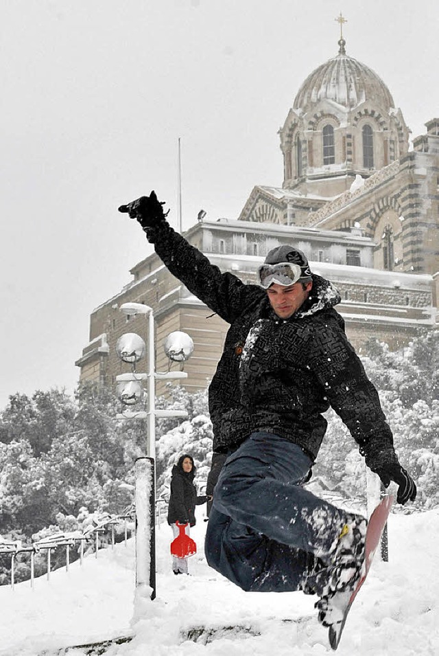 Dieser Snowboarder bt vor der Kirche ...#8220; in Marseille in Sdfrankreich.   | Foto: dpa (2)/AFP