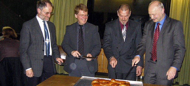 Pfarrer Martin Auffarth, Pfarrer Huber... beim Anschneiden der Neujahrsbrezel.   | Foto: otto selb
