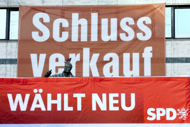 Ein Plakat der Hessen-SPD hngt  in Ka... Schlussverkauf eines Geschfts wirbt.  | Foto: dpa