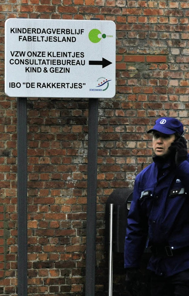 Ein Polizist steht vor der Kindertagessttte in Dendermonde.  | Foto: AFP