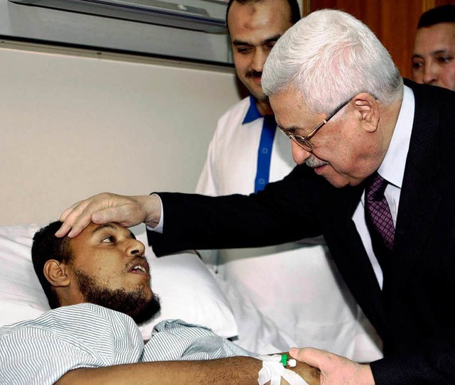 Palstinenserprsident Mahmud Abbas   ...nkenbett eines verletzten Landsmannes.  | Foto: dpa