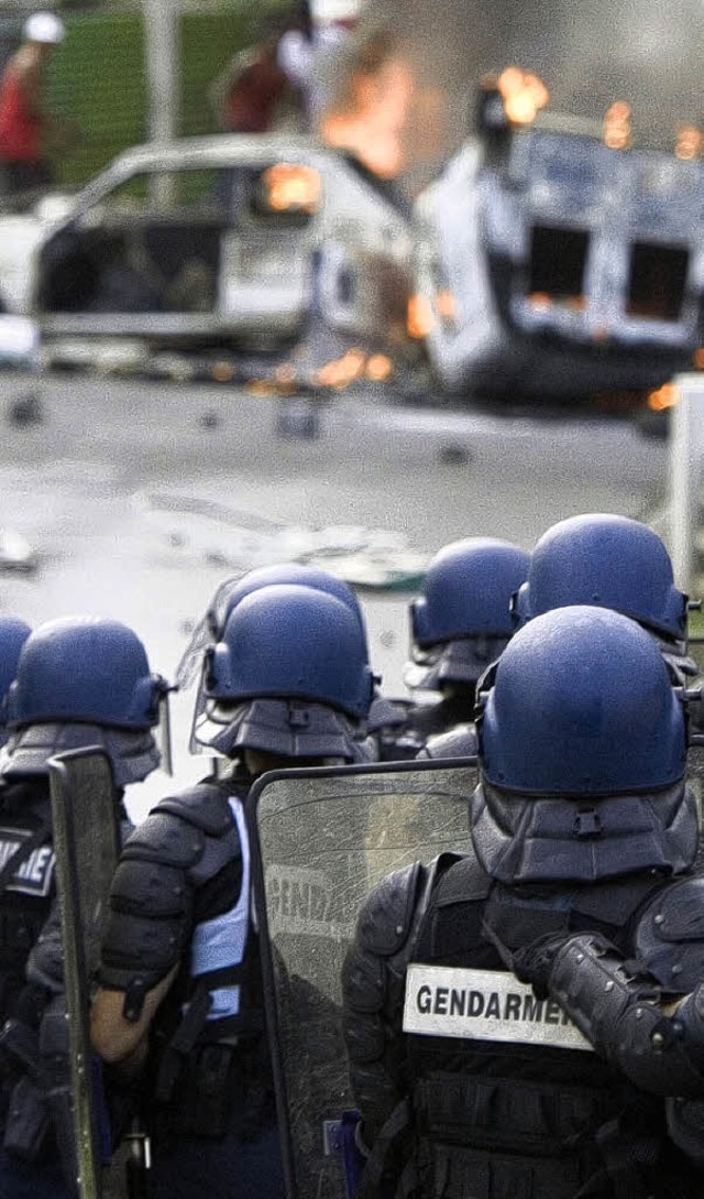 Polizisten knnen nicht verhindern, da... Guadeloupe Autos angezndet werden.    | Foto: AFP