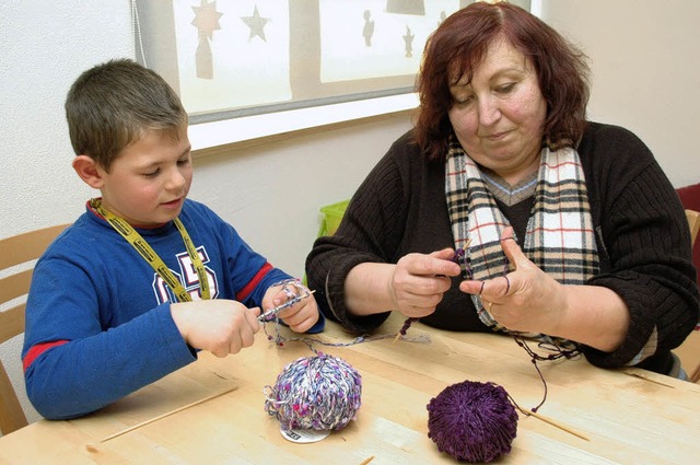 Ideengeberin Margarete Ossola bringt einem kleinen Helfer das Stricken bei.  | Foto: Hubert Bleyer