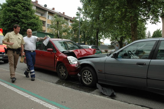 Polizei und Rettungsdienst betrachten ...chaden. Beide Autos sind schrottreif.   | Foto: Ralf H. Dorweiler