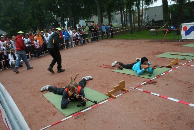 Die Biathlon-Profis Benedikt Doll und ... kleinen Teilnehmer die Richtzeit vor.  | Foto: Maurer