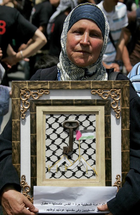 Eine Palästinenserin hat  den Schlüsse...tsgründung  verloren hat, eingerahmt.   | Foto: AFP