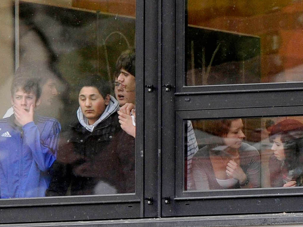 Schler stehen am Fenster des Schulzentrums.
