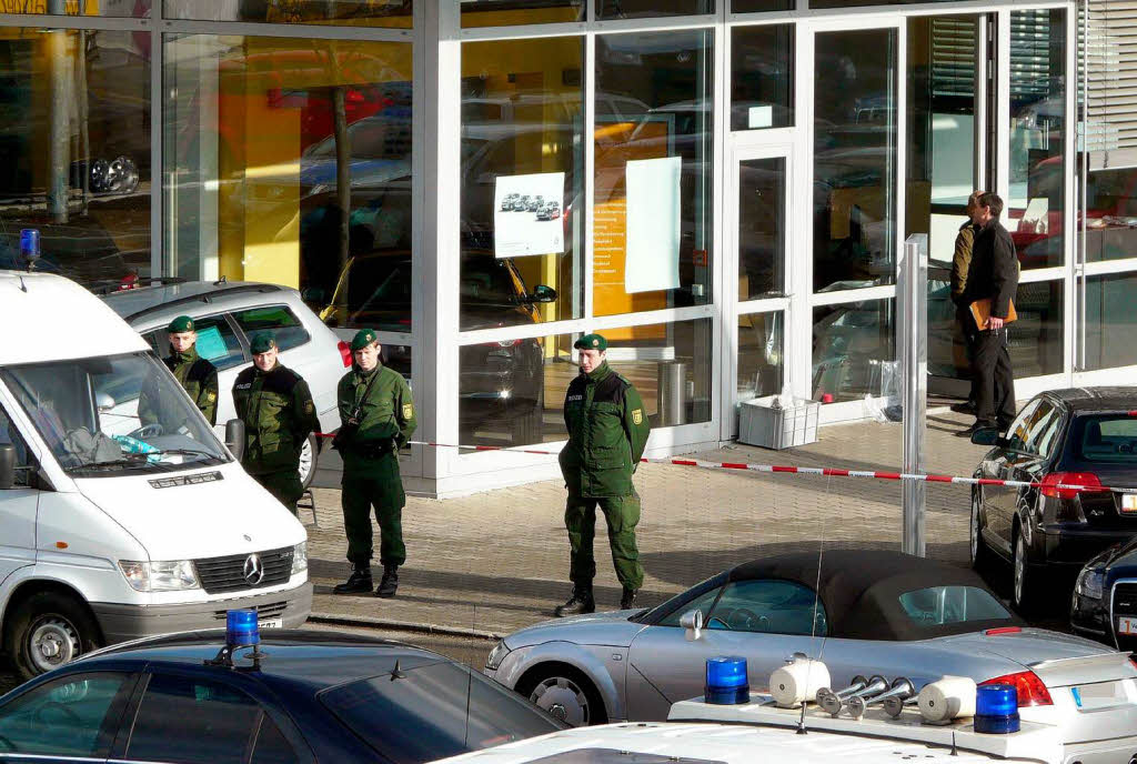 Polizeibeamte stehen vor dem Autohaus in Wendlingen, an dem der Amoklauf endete.