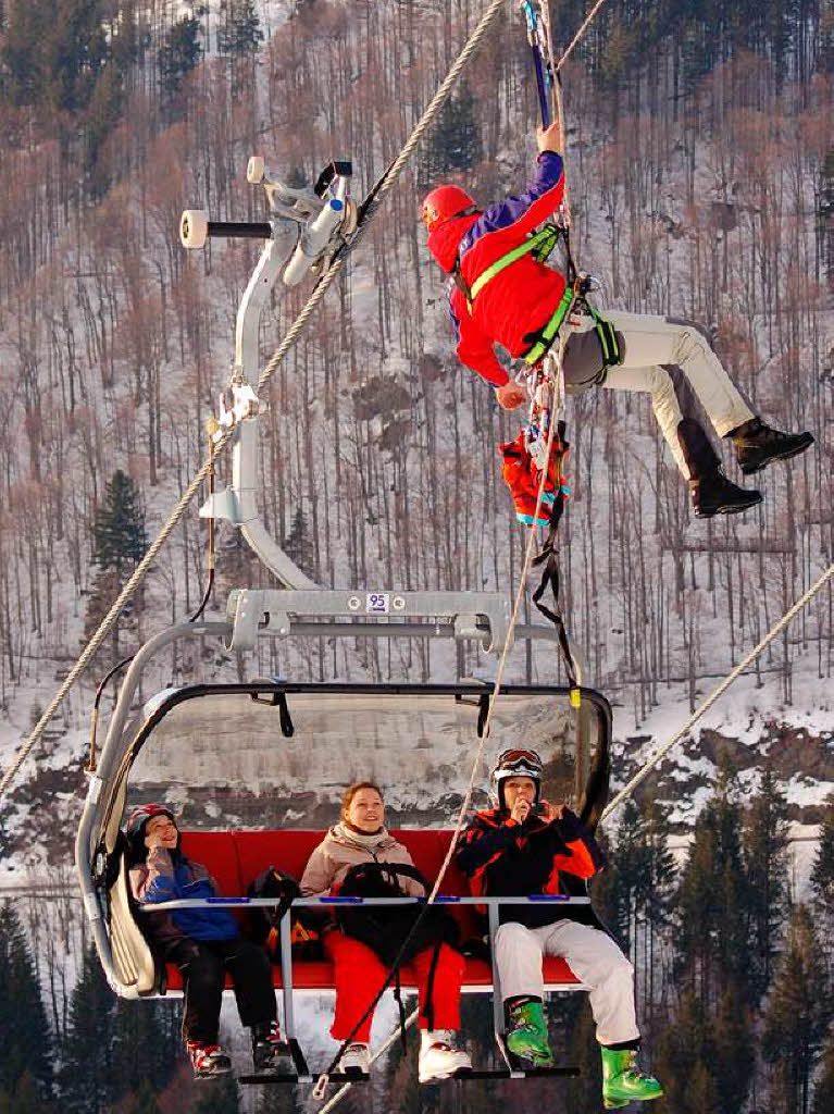 <Bildtext>Ein Retter der Bergwacht Todtnau seilt sich, gesichert von seinen Kameraden, zu den Passagieren auf dem Sessel ab.</Bildtext>