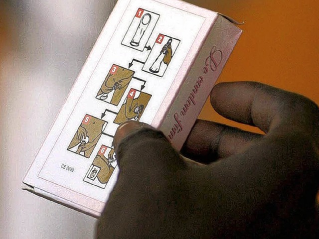 Ein senegalesischer Student betrachtet die Anleitung auf einer Packung Kondome.  | Foto: dpa