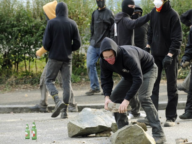 Demonstranten suchen neue Wurfgeschosse.  | Foto: AFP