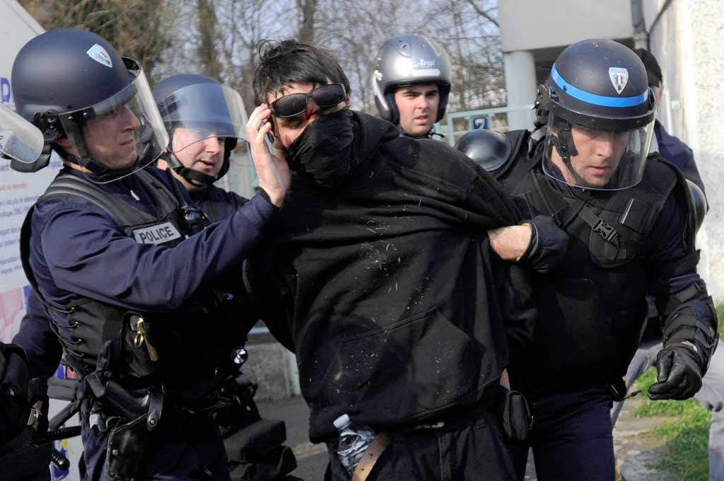 Polizisten nehmen in Strassburg einen Demonstranten fest.