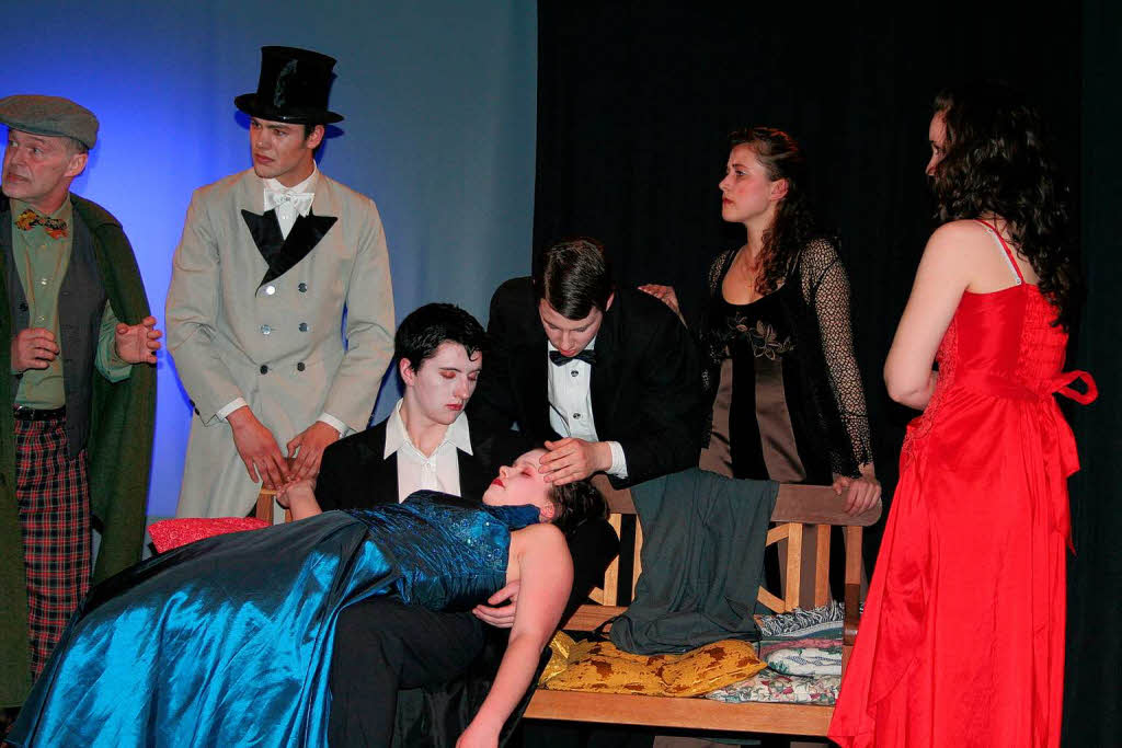 Die Sommergesellschaft umringt ratlos Graf Dracula (Christian Wildschut) der die bewusstlose Lucy (Elora Oswld) auf dem Scho hlt.