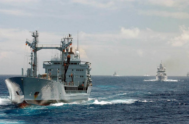 Ein Marineschiff der Nato beschtzt ein Frachtschiff vor somalischen Piraten  | Foto: dpa