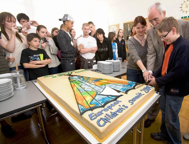 Zur Erffnung des Kindergipfels schnit...ken mit zwei Teilnehmern die Torte an.  | Foto: ddp