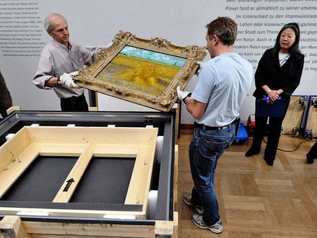 Die Museumsmitarbeiter Dieter Marti (l... Bosch nehmen das Bild aus der Kiste.   | Foto: dpa