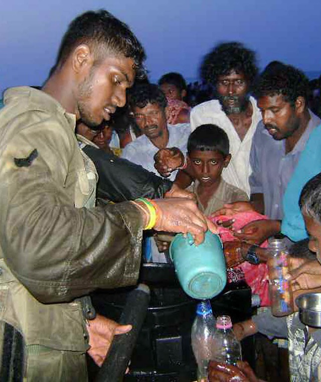 Ein  Soldat (Bild der Armee)  verteilt Wasser an Flchtlinge.   | Foto: AFP