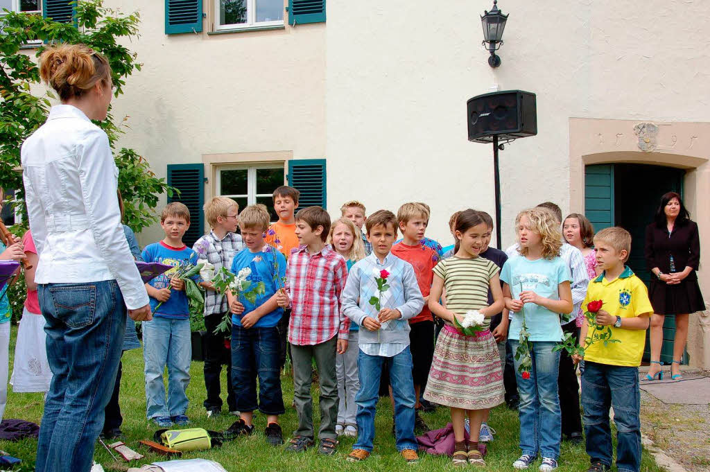 Noch halten die Kinder die Blumen, die sie gleich Markus Riesterer berreichen werden.