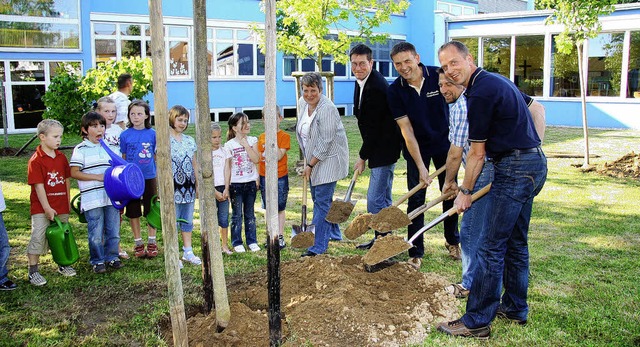 Gemeinsame Pflanzaktion: Mitglieder de...htet von  Grundschlern, zur Schaufel.  | Foto: Sandra DEcoux-Kone