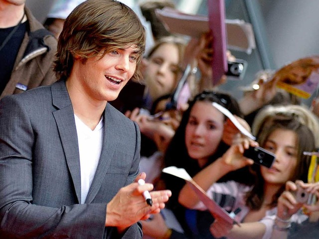 Von den Fans belagert: Zac Efron beim Autogramme schreiben.  | Foto: ddp