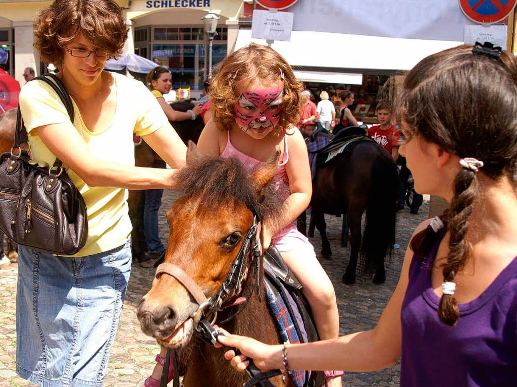 Mit fantasievoll geschminktem Gesicht auf dem Pony Runden drehen – was will man mehr?